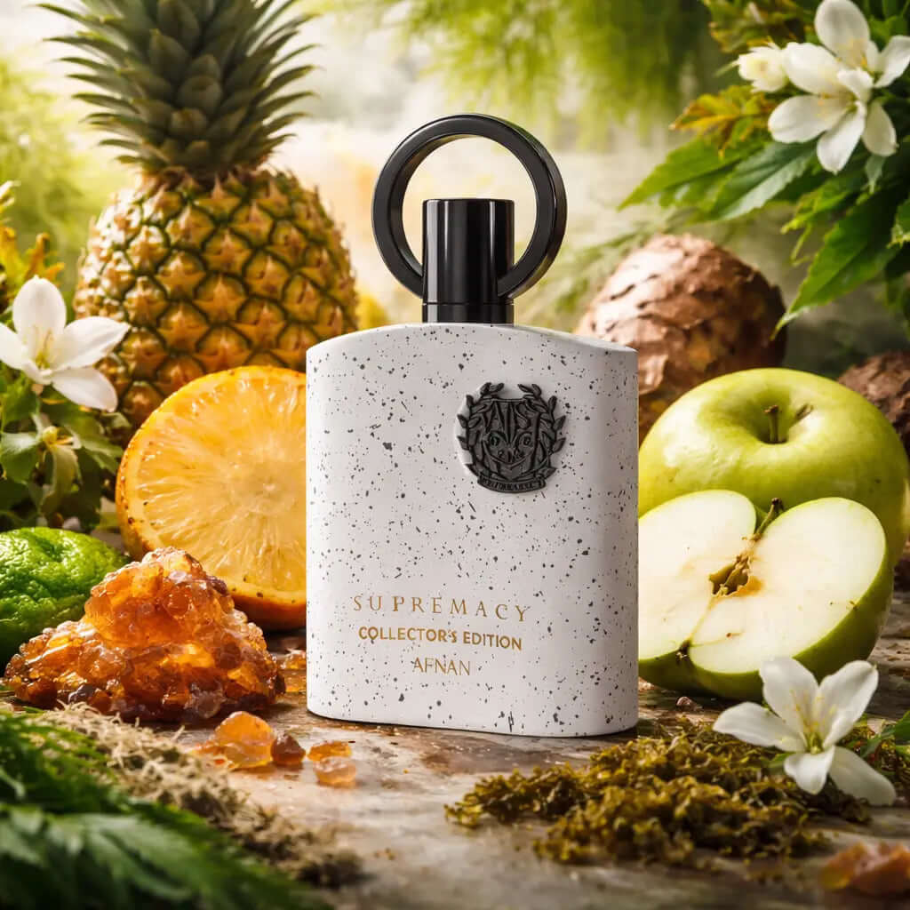 AFNAN SUPREMACY COLLECTORS EDITION Perfume bottle labeled 'Supremacy Collector's Edition' surrounded by fruits and plants on a wooden surface.